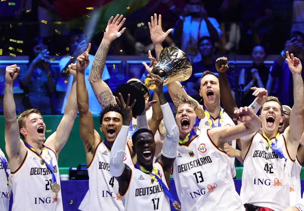Germany's Dennis Schroder lifts the trophy after his team's win over Serbia in the Basketball World Cup final in Manila on Sunday.