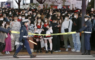 Police officers guide the Halloween crowd at the Shibuya scramble crossing in Tokyo on Oct. 31 last year.
