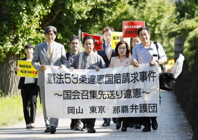 A team of lawyers — which represent the plaintiffs of a lawsuit claiming that former Prime Minister Shinzo Abe and his Cabinet neglected their constitutional obligation to call a parliamentary session — walk to the Supreme Court on Tuesday.