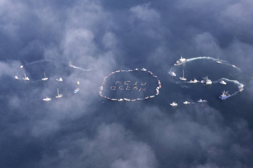 Commercial fishermen form the word "SOS" to spread the message about ocean acidification caused by fossil fuel emissions, in Homer, Alaska, in 2009. Ocean acidification is one of nine planetary boundaries that determine life on Earth. 