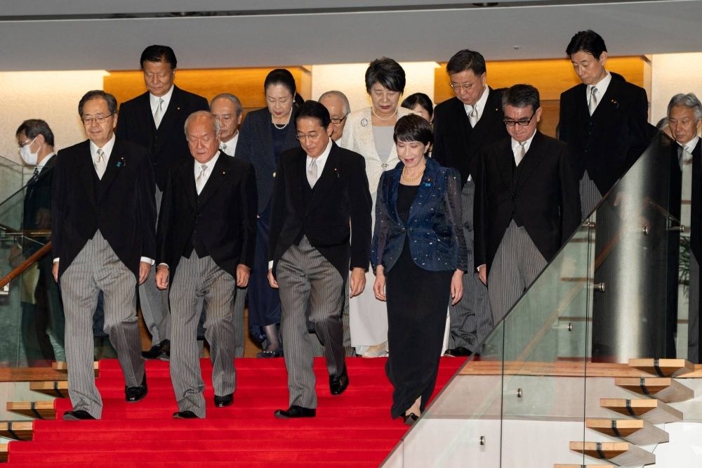 Prime Minister Fumio Kishida and members of his new Cabinet at the Prime Minister's Office in Tokyo on Wednesday