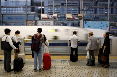 Passengers wait to board a shinkansen at Kyoto Station. 