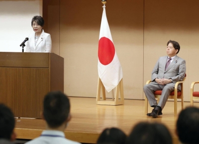 Foreign Minister Yoko Kamikawa speaks at the Foreign Ministry on Thursday, a day after she was named as the replacement of Yoshimasa Hayashi (right) in a Cabinet reshuffle.