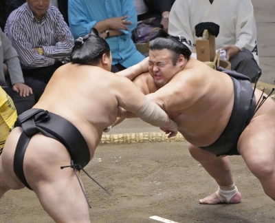 Takakeisho (right) battles Abi during their bout at the Autumn Grand Sumo Tournament at Ryogoku Kokugikan on Thursday.