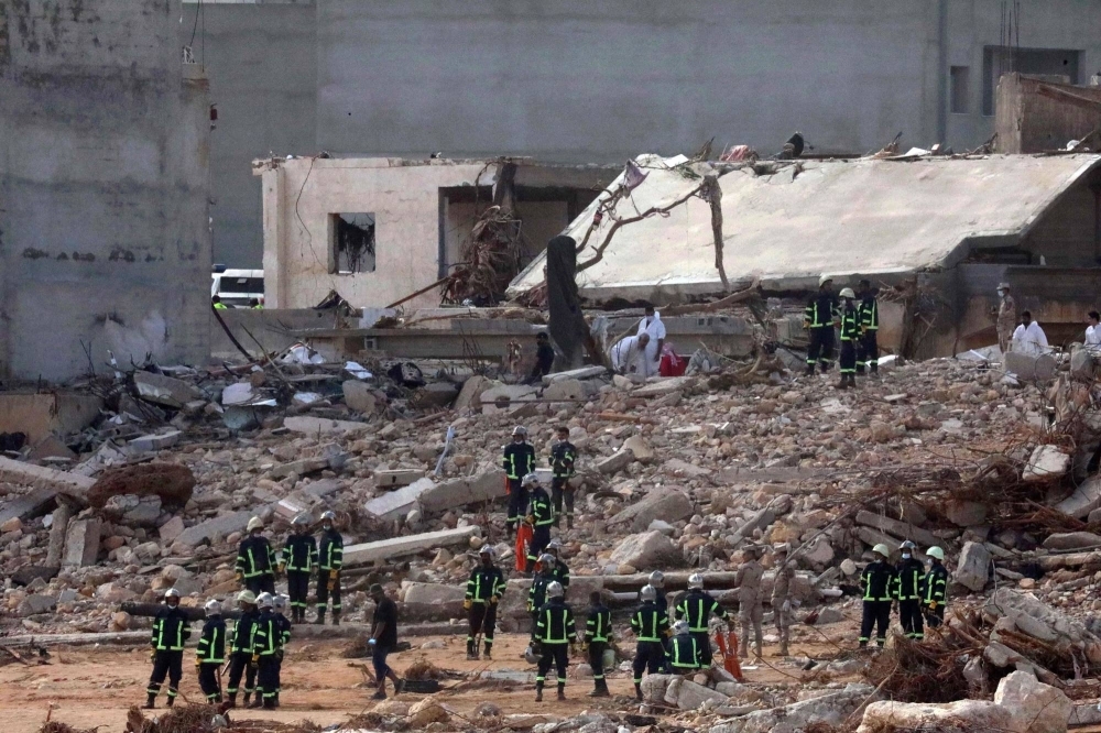 Rescuers gather on Thursday amid the rubble of buildings damaged or leveled in flash floods after a Mediterranean storm hit the eastern Libyan city of Derna.