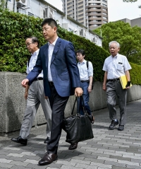 Lawyers for the plaintiff in a lawsuit demanding that the Finance Ministry disclose documents related to a document-tampering scandal walk to the Osaka District Court on Thursday. | Kyodo