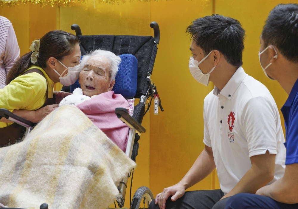 Japan's oldest person Fusa Tatsumi (center) is greeted by Osaka Gov. Hirofumi Yoshimura (second from right) in Kashiwara, Osaka Prefecture, in September 2022.