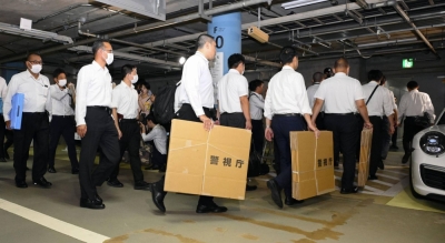 Police investigators head to Bigomotor's headquarters on the 20th floor of the Roppongi Hills complex in Tokyo's Minato Ward from an underground parking on Friday.