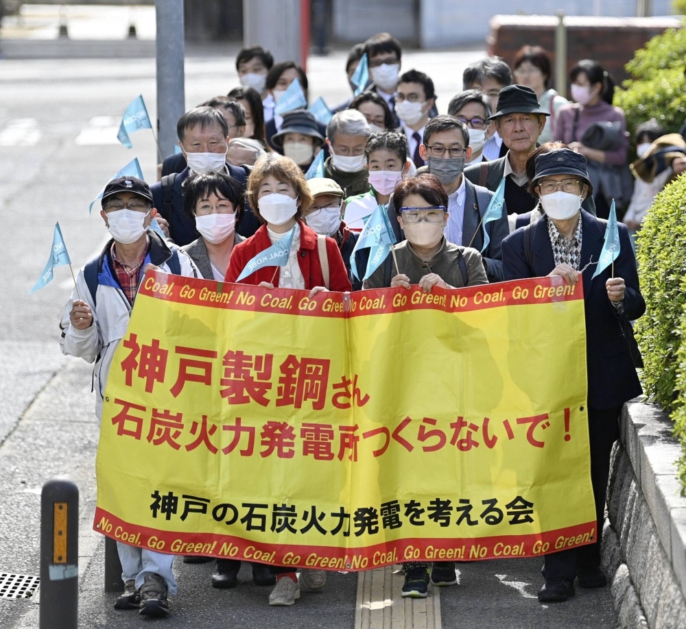 Plaintiffs and supporters of a civil lawsuit against the expansion of a coal-fired power plant in Kobe march to the Kobe District Court in March.