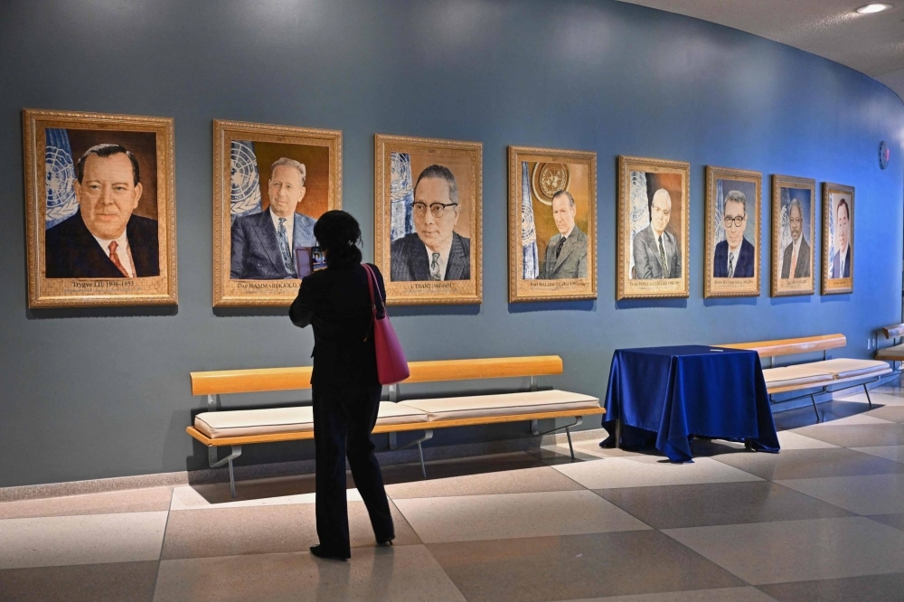 A visitor looks at portraits of former United Nations Secretaries-General at U.N. headquarters ahead of the 78th session of the United Nations General Assembly in New York on Friday.