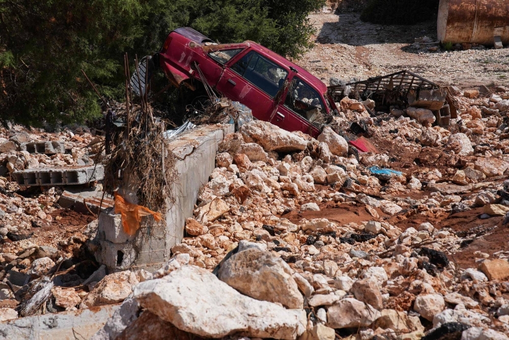 A car is buried in rubble and debris in the aftermath of a devastating flood in al-Bayda, Libya, on Saturday.