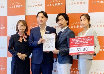 Masanobu Ogura (center left), then-minister in charge of policies related to children, receives a petition from Hiroki Komazaki (center right), founder of nonprofit organization Florence, in Tokyo on Sept. 1.