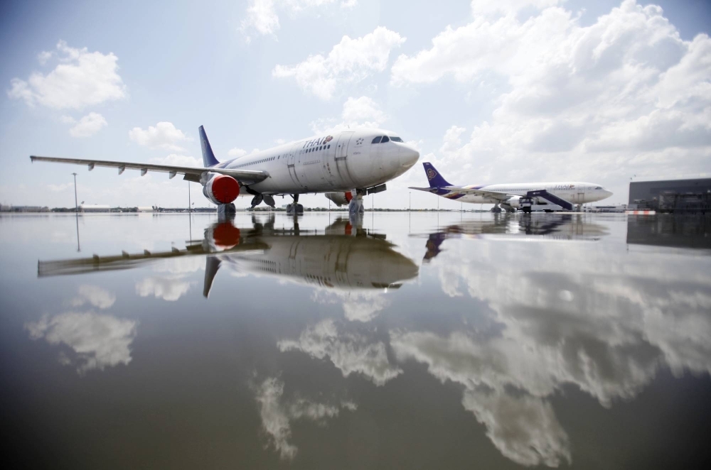A Thai Airways Airbus A300 sits parked on the flooded tarmac at Don Muang airport in Bangkok.