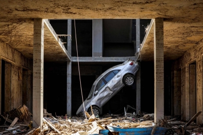 A car sits precariously above debris in Libya's eastern city of Derna on Monday following deadly flash floods.