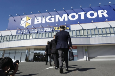 Financial Services Agency officials enter Bigmotor's Tama outlet in western Tokyo on Tuesday.