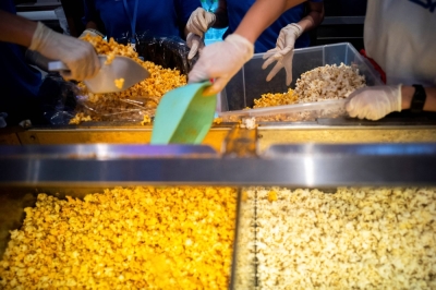 Cinema staff prepare servings of popcorn during an "all you can eat popcorn for 199 baht" campaign in front of a cinema inside a department store in Bangkok in November 2022.