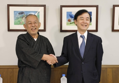 Studio Ghibli President Toshio Suzuki (left) and Nippon TV Chairman Yoshikuni Sugiyama shake hands during a news conference in Tokyo on Thursday afternoon.
