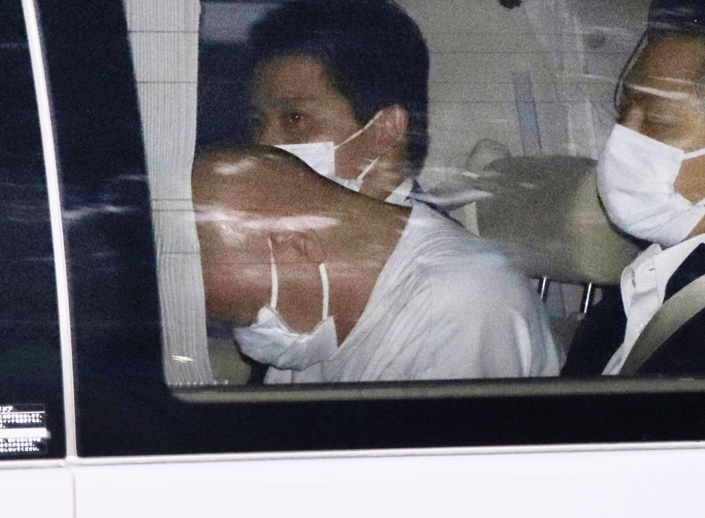 Yusuke Hashimoto (center) leaves the Metropolitan Police Department in a police car on Thursday.
