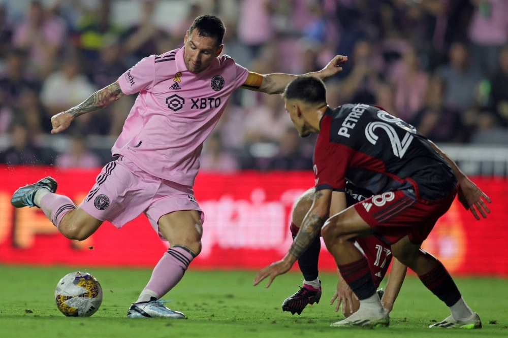 Inter Miami forward Lionel Messi (left) shoots against Toronto FC defender Raoul Petretta at DRV PNK Stadium in Fort Lauderdale, Florida, on Wednesday.