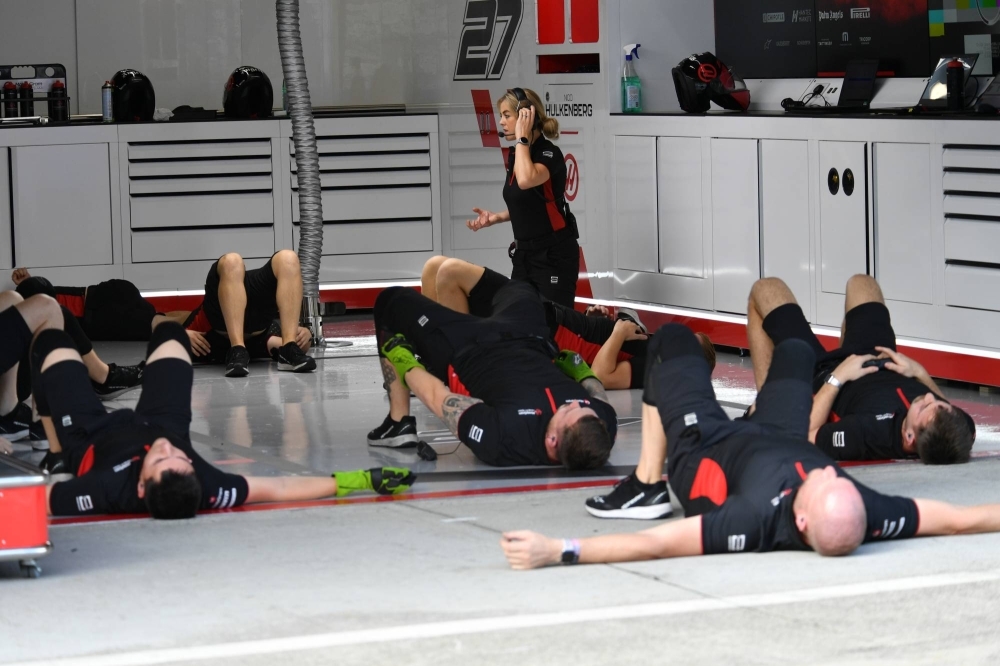 Haas crew members go through stretching exercises on Friday morning.