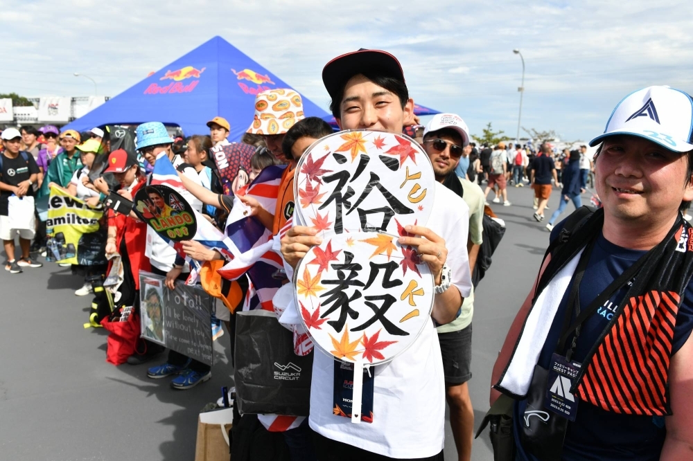 A Yuki Tsunoda fan poses outside Suzuka Circuit.