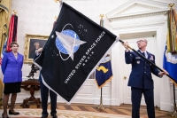 The official U.S. Space Force flag is held during a presentation in the Oval Office of the White House in Washington in May 2020.  | The New York Times / VIA Bloomberg