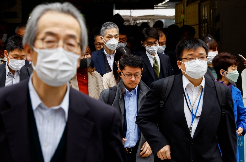 Commuters wear masks in Tokyo. The number of new influenza cases reported at designated medical institutions in Japan has surged 57% over the past week, health ministry data has shown.