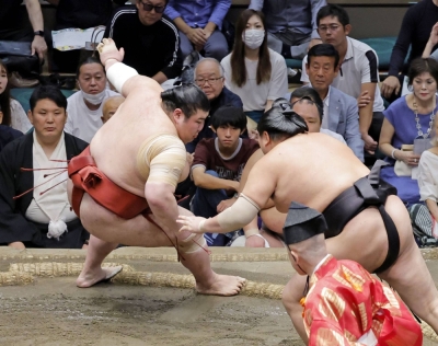 Atamifuji resisting the attack of Abi (right) on Day 14 of the Autumn Grand Sumo Tournament at Ryogoku Kokugikan in Tokyo on Saturday.