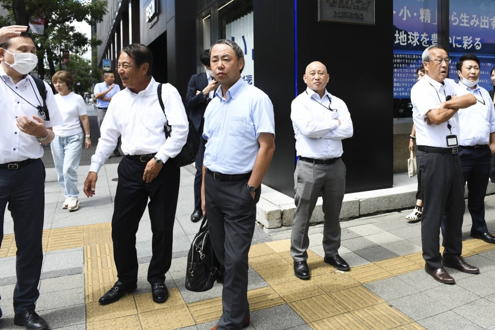 Office workers in a business district of Tokyo on Sept. 12. Under Cool Biz, salarymen and government workers don short-sleeved shirts in the summer as offices are kept above 28 degrees Celsius to save energy.