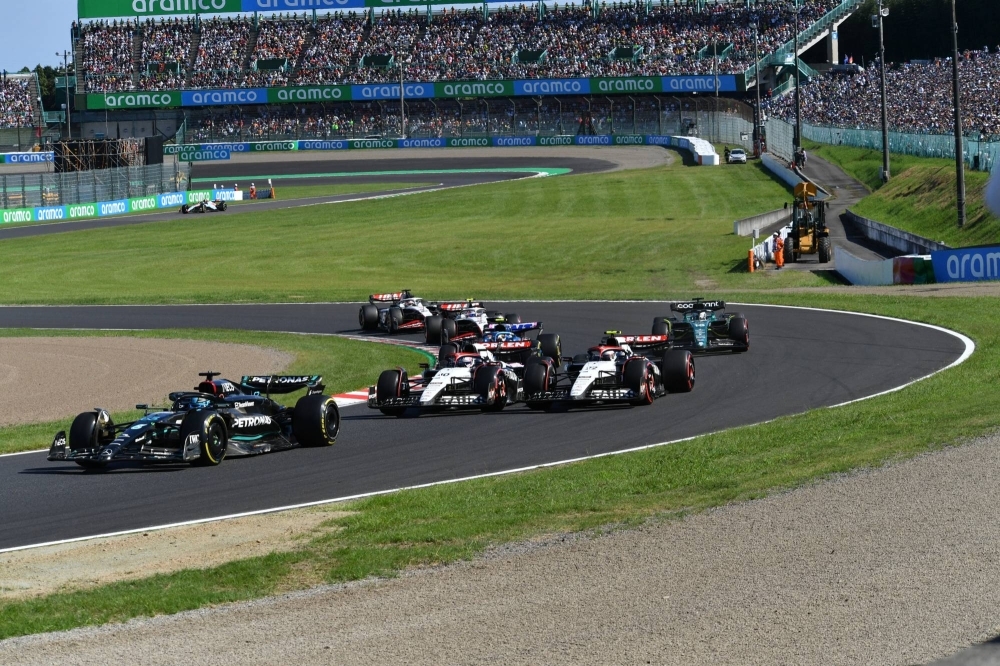 Formula One cars race around Suzuka Circuit at the start of the Japanese Grand Prix.