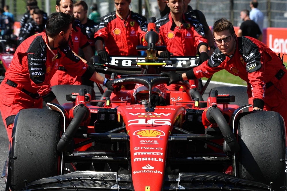 Ferrari engineers roll Charles Leclerc's car into position ahead of the race.