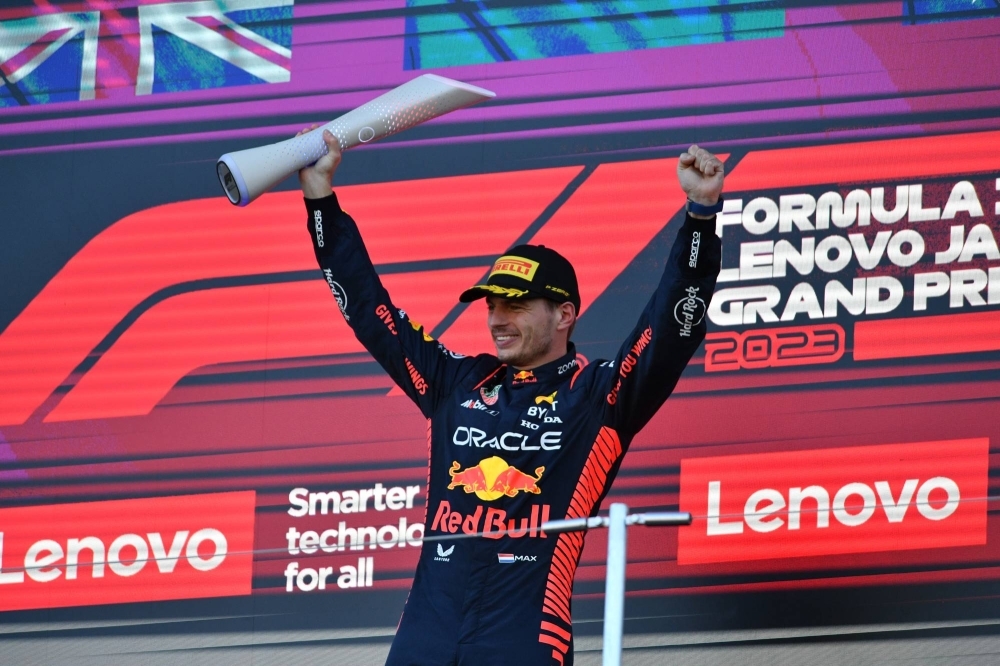 Verstappen celebrates after receiving the winner's trophy at Suzuka.
