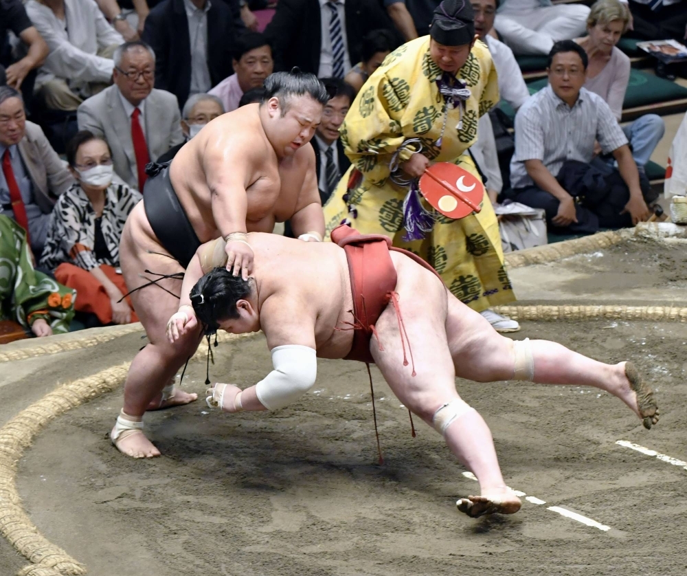 Takakeisho defeated Atamifuji (right) in the title match on Day 15 of the Autumn Grand Sumo Tournament at Ryogoku Kokugikan in Tokyo on Sunday.