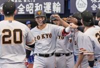Giants' Hayato Sakamoto celebrates with teammates after hitting a 3-run home run against the BayStars at Yokohama Stadium on Sunday. | Kyodo
