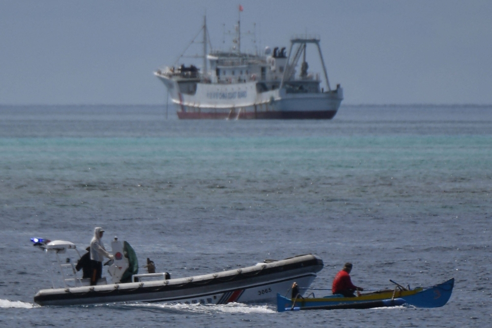 A boat piloted by a Philippine fisherman is intercepted by Chinese coast guard boats as they tried to enter the Scarborough Shoal in disputed waters of the South China Sea.