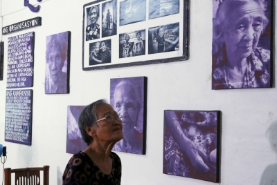 A Filipino woman looks at pictures of fellow wartime survivors of sexual servitude at a resource center, in Quezon city, Manila, in August 2015.