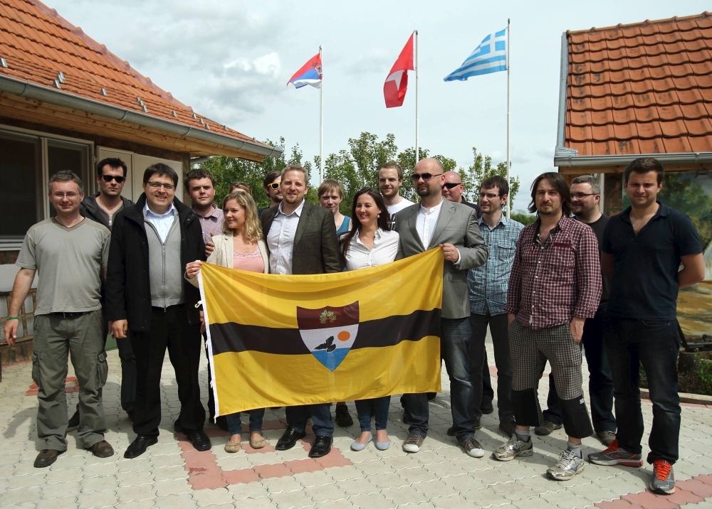 Self-proclaimed president of the "Free Republic of Liberland" Vit Jedlicka (center) poses with the Liberland flag and future citizens in the village of Backi Monostor, Serbia, in May 2015