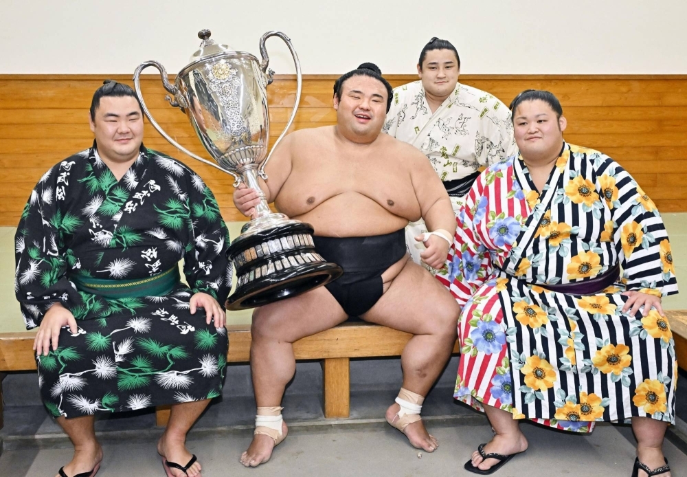 Takakeisho (center) celebrates after winning the Autumn Grand Sumo Tournament at Ryogoku Kokugikan on Sunday.