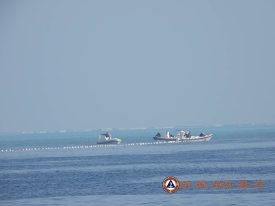 China Coast Guard boats are seen close to a floating barrier near the Scarborough Shoal in the South China Sea on Friday. 