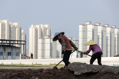 Workers in front of residential buildings under construction at the Phoenix Palace project, developed by Country Garden Holdings, in Guangdong province, China, on Sept. 21