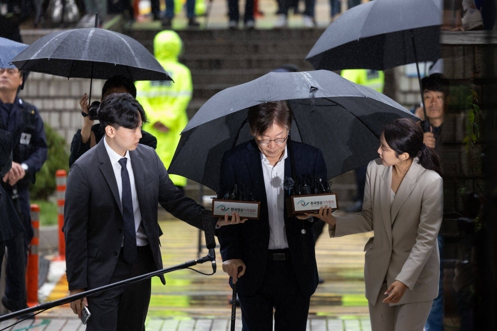 Lee Jae-myung (center), leader of South Korea's opposition Democratic Party, arrives at the Seoul Central District Court in Seoul on Tuesday.