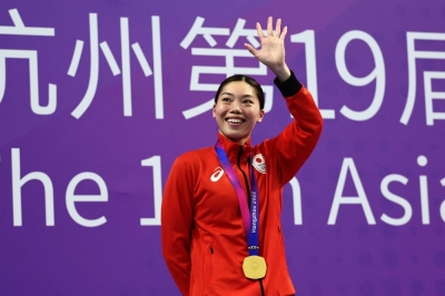 Reona Aoki celebrates during the medal ceremony after winning gold in the women's 100-meter breaststroke at the Asian Games in Hangzhou, China, on Wednesday.
