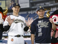 Buffaloes pitcher Sachiya Yamasaki (left), who earned his 10th win of the season, and catcher Kenya Wakatsuki pose after their game against the Hawks in Osaka on Wednesday. | KYODO