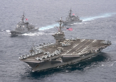Two Japanese Maritime Self-Defense Force destroyers escort the U.S. Navy aircraft carrier USS Carl Vinson during a transit mission in the Philippine Sea in April 2017.