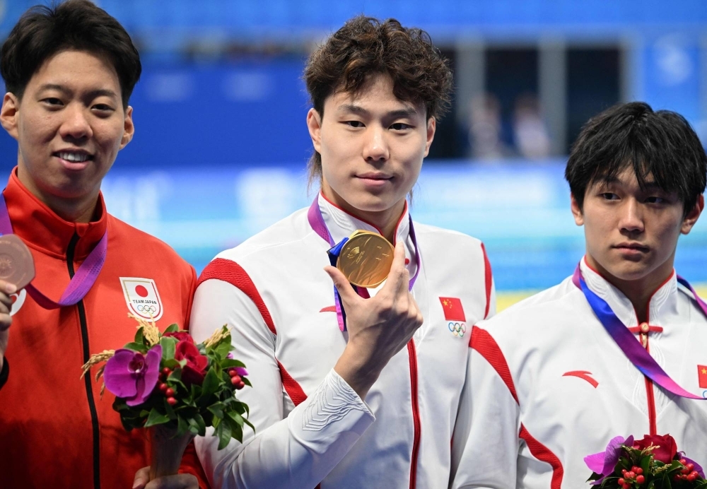 Qin Haiyang (center) poses with his gold medal alongside silver medalist Dong Zhihao (right) and Ippei Watanabe, who finished third, following the men's 200-meter breaststroke at the Asian Games in Hangzhou, China, on Thursday.