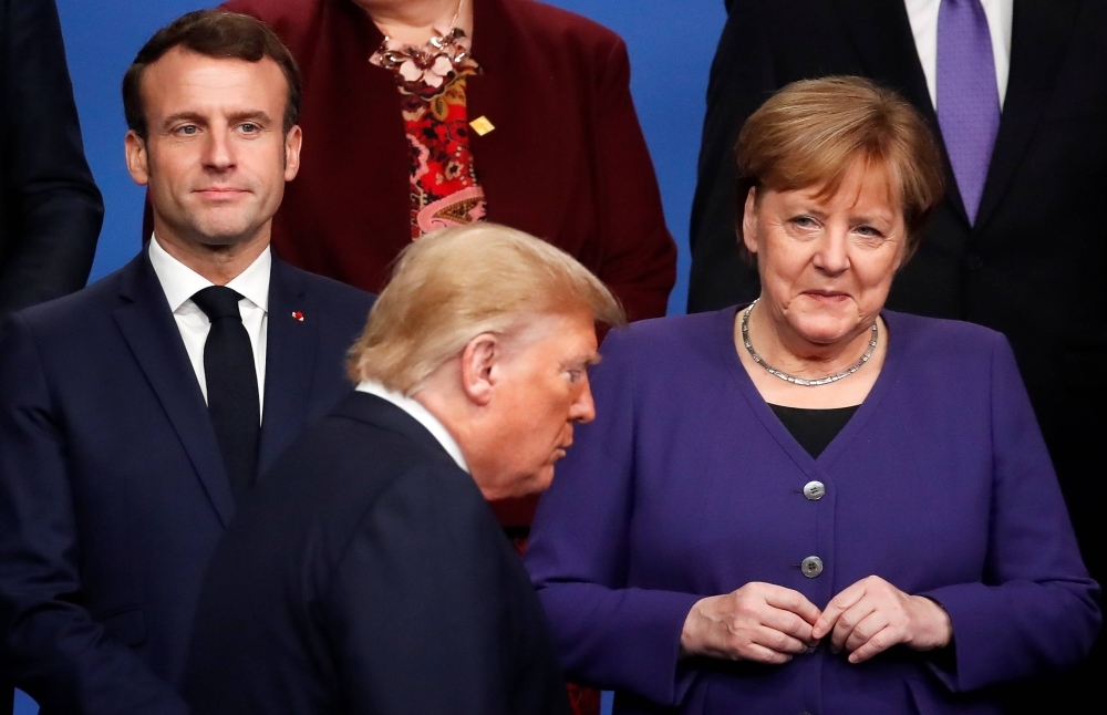 French President Emmanuel Macron, then-German Chancellor Angela Merkel and then-U.S. President Donald Trump during a photo opportunity at a NATO leaders summit in the U.K. in 2019. 