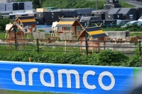 "Bee hotels" at Suzuka Circuit created by former Formula One driver Sebastian Vettel in a bid to raise awareness about the world's biodiversity crisis. An ad for Saudi Aramco is in the foreground, while freight containers used to bring F1 racing to 20 countries are in the background.  | Dan Orlowitz 