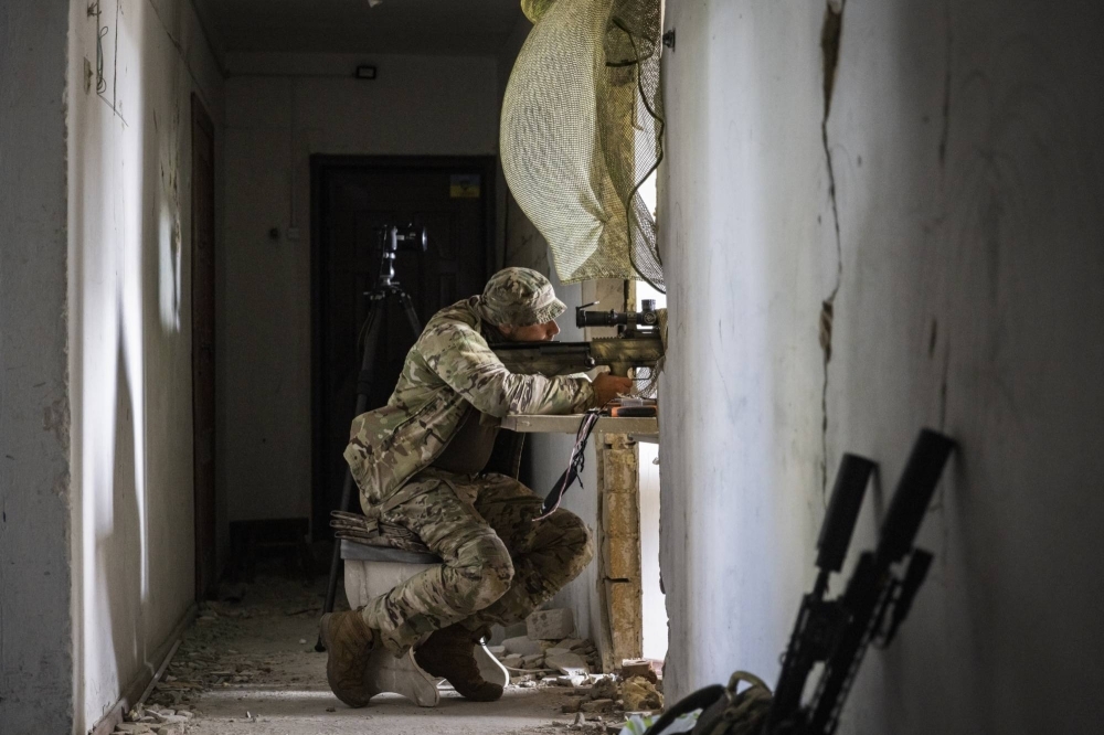 A Ukrainian sniper with the call sign Bart patiently waits at an abandoned building overlooking a Russian position, in southern Ukraine, on Sept. 21.