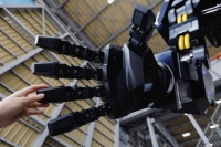 Tsubame Industries Co. CEO Ryo Yoshida touches the hand of ARCHAX, a giant human-piloted robot developed by his startup, in Yokohama on Sept. 27. | REUTERS