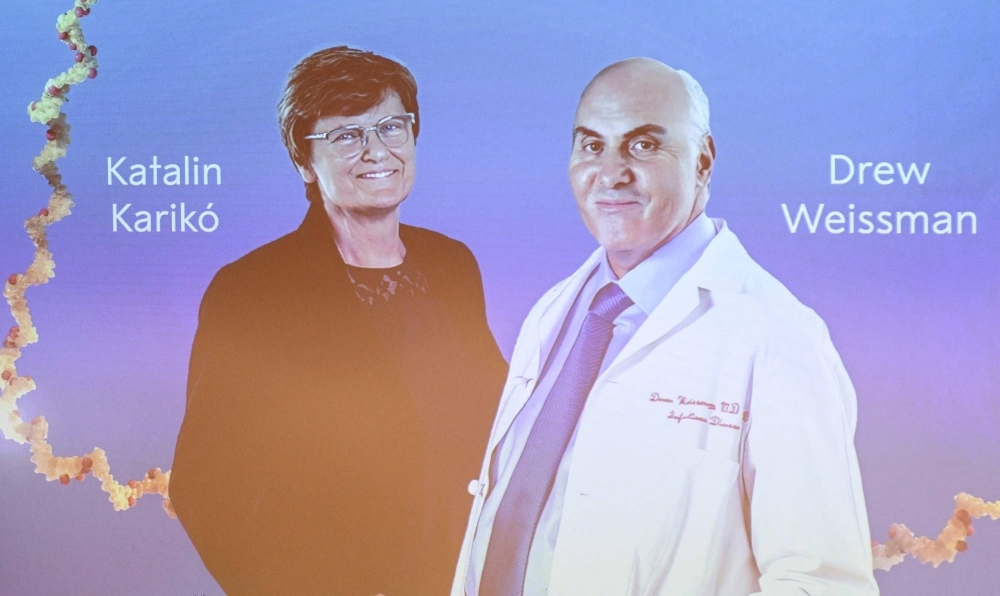 A screen at the Karolinska Institute shows this year's laureates Katalin Kariko of Hungary (left) and Drew Weissman of the U.S. during the announcement of the winners of the Nobel Prize in physiology or medicine.